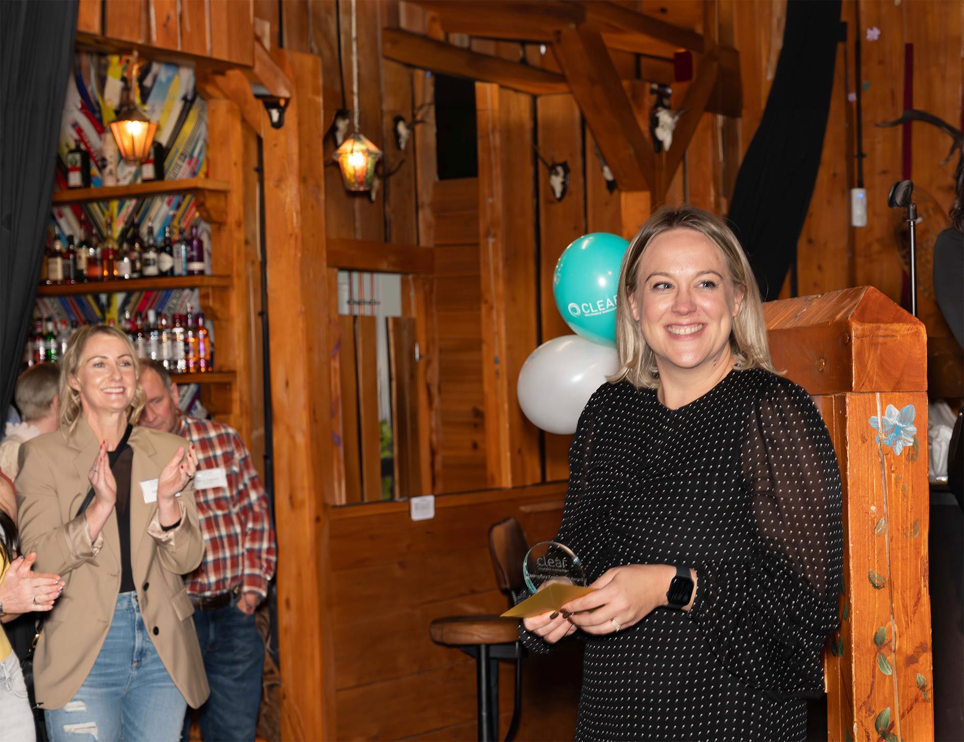 Female Clear staff member accepting an award at a Clear event